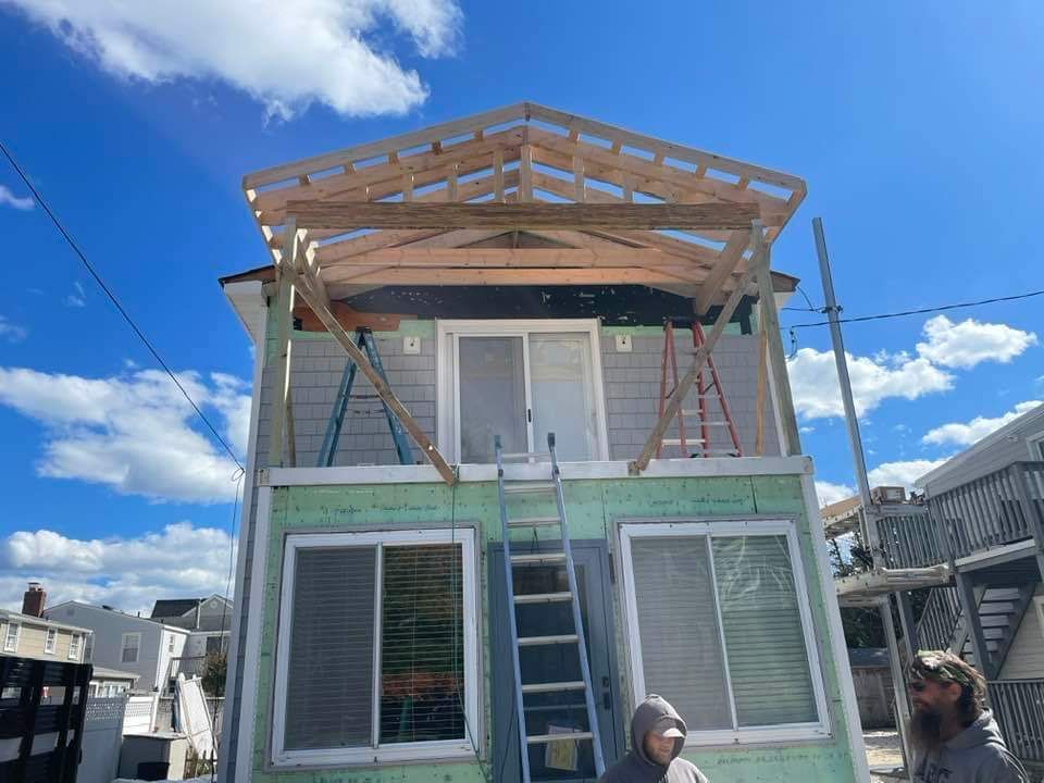 A small house is being built with a wooden roof.