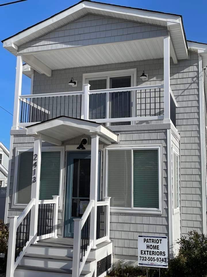 A house with a sign that says patriot home exteriors