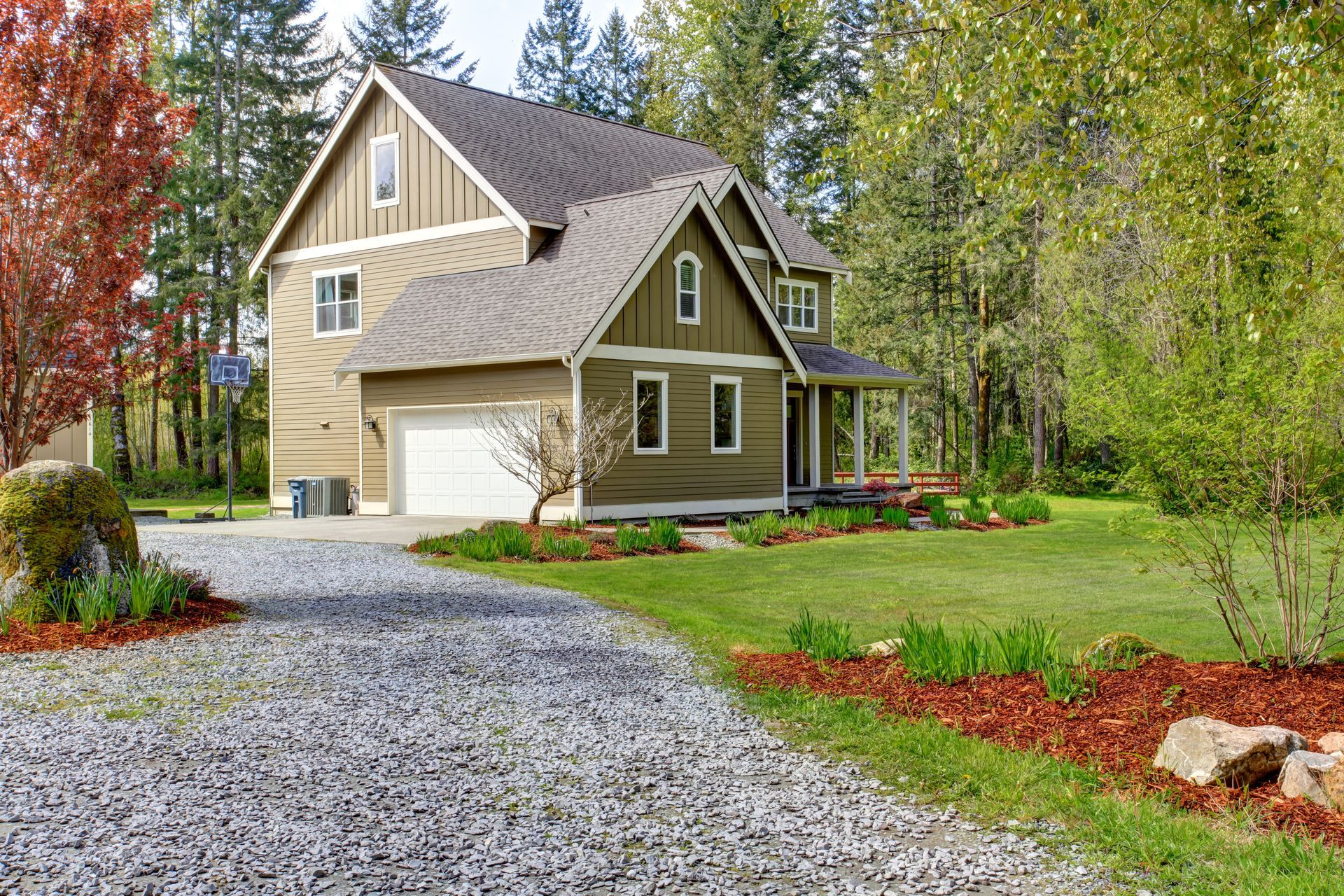 a large house with a gravel driveway leading to it .