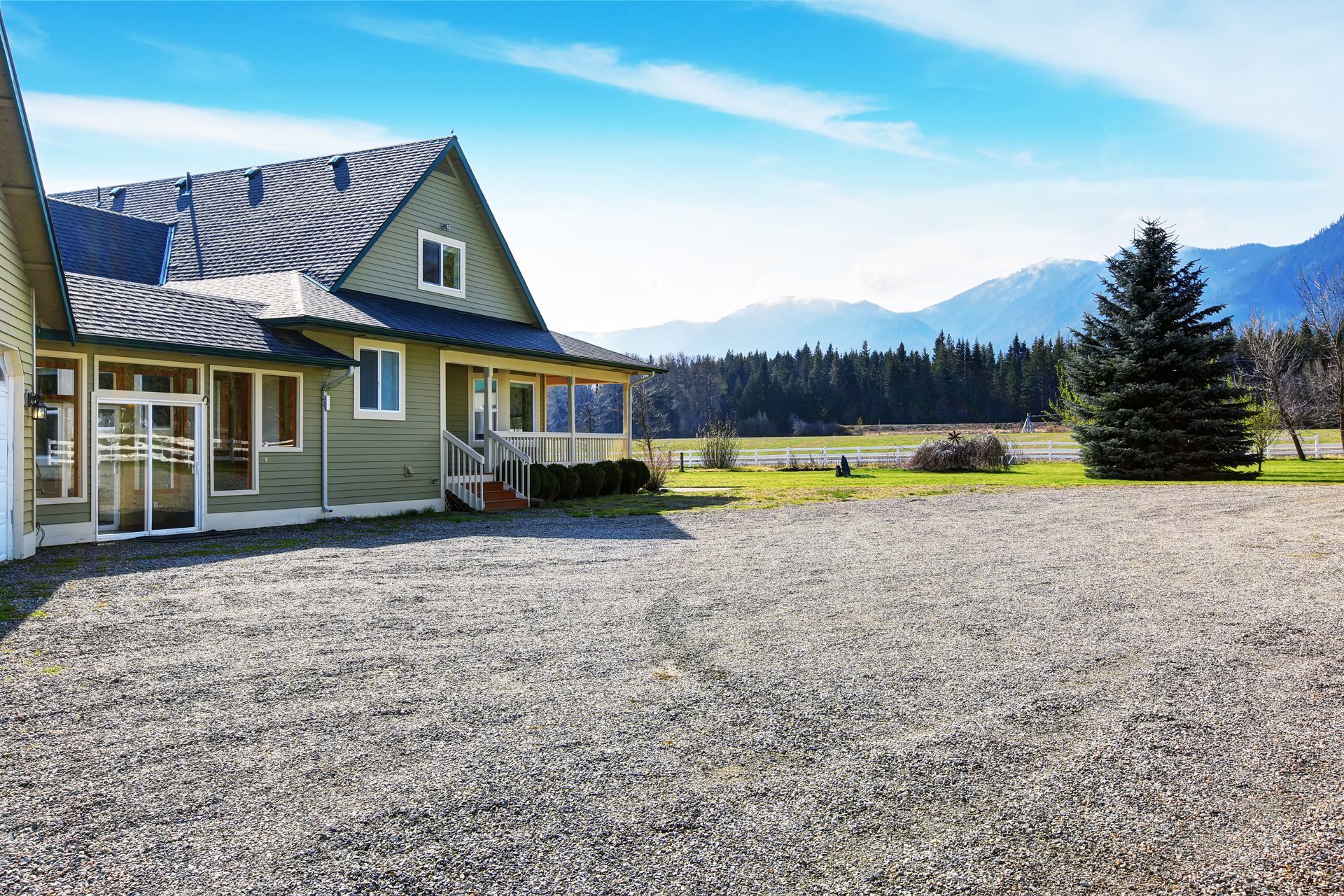 a house with a lush green lawn and a rock garden in front of it .