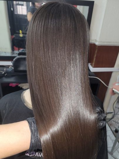 Cabello largo, liso, brillante y castaño oscuro con un acabado suave, visto desde atrás.