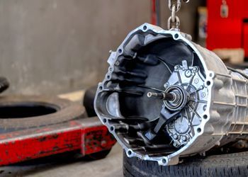 A close up of a gearbox sitting on top of a tire.