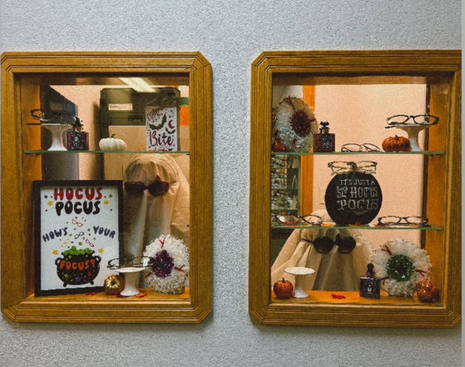 Two Halloween-themed display cases with glasses and spooky decorations. One says 