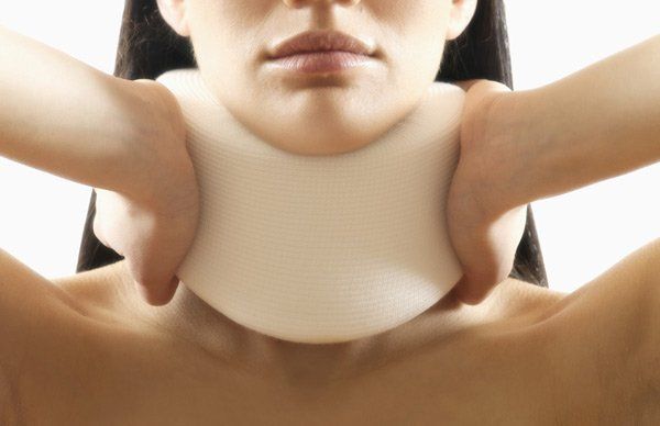 woman holding a cushion to her neck