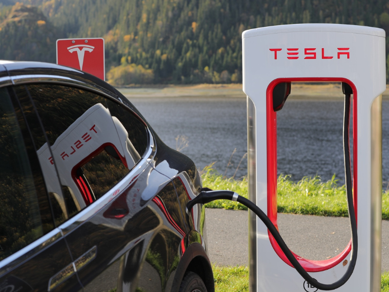 a tesla car is being charged at a charging station