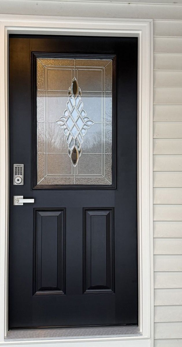 A black exterior door with a decorative glass window panel, a modern silver handle, and a keypad lock.