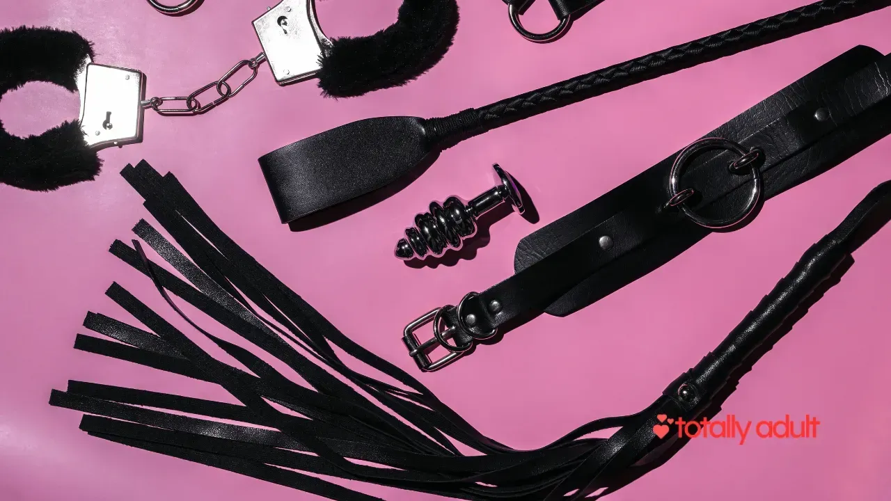 An array of adult sex toys, such as handcuffs, a whip, and an anal plug, available from an online sex shop in New Zealand, offering discreet and private shopping experiences compared to physical stores. 