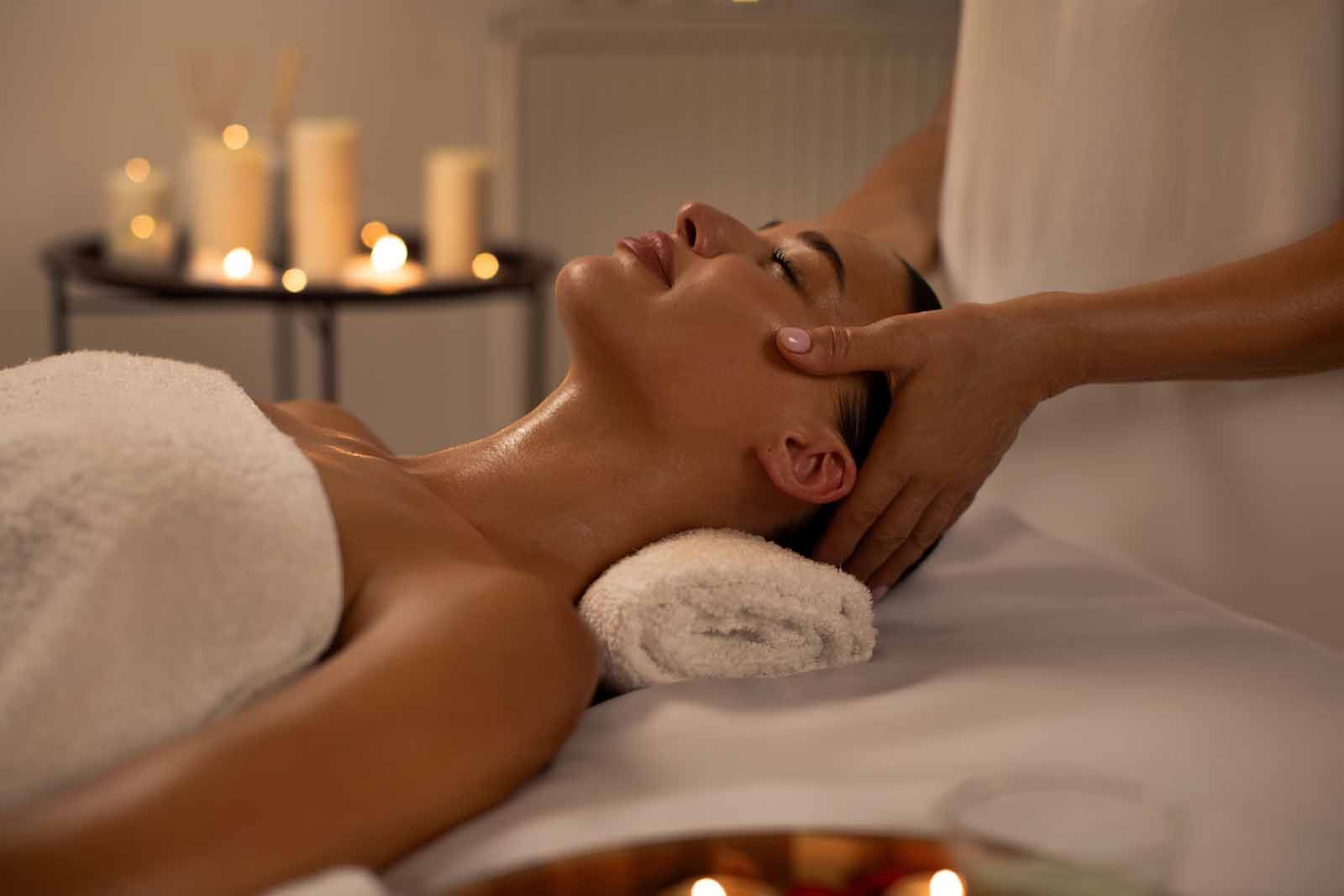 A woman is getting a head massage at a spa.