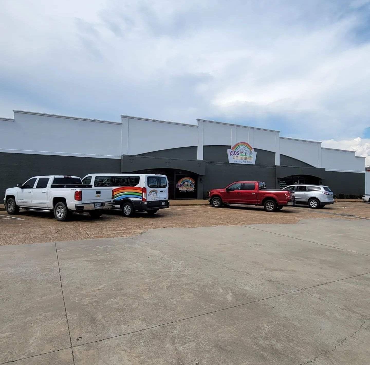 A row of trucks are parked in front of a building.
