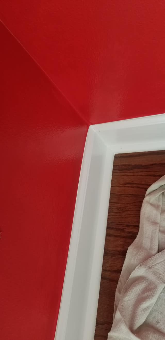 A close up of a picture frame on a red wall.