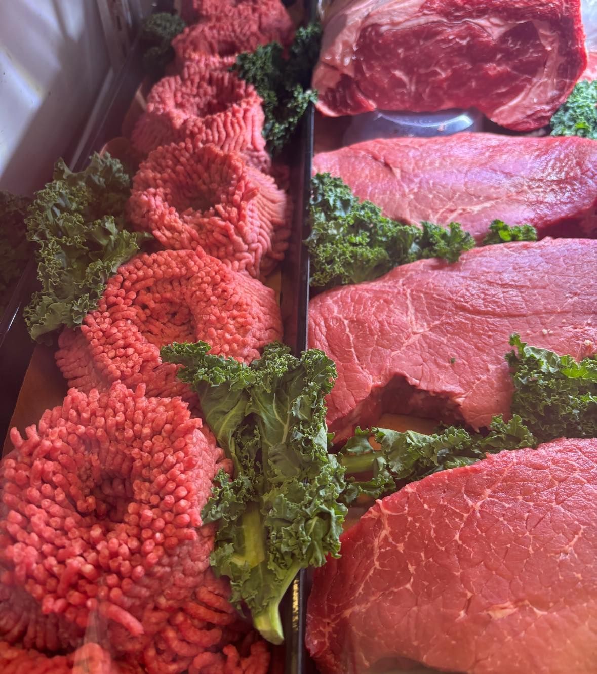 There are many different types of meat and vegetables on the table.