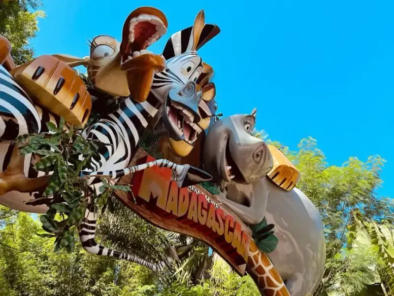 Escultura dos personagens de Madagascar: Alex, o leão; Marty, a zebra; e outros, contra um céu azul.