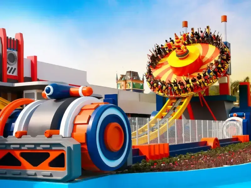 Atração de parque temático com disco giratório e trilho de montanha-russa, design laranja e azul.