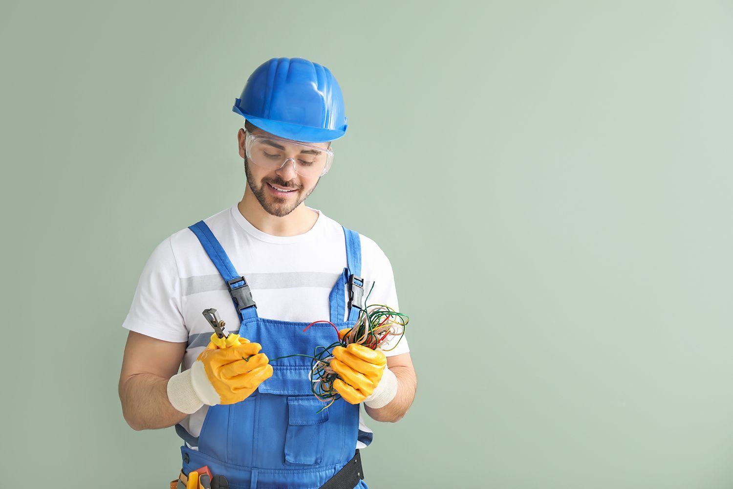 Male electrician on color background.