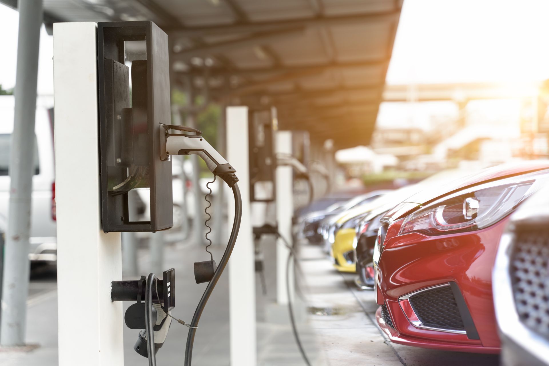 Electric cars parked outdoors by electric car charging stations.