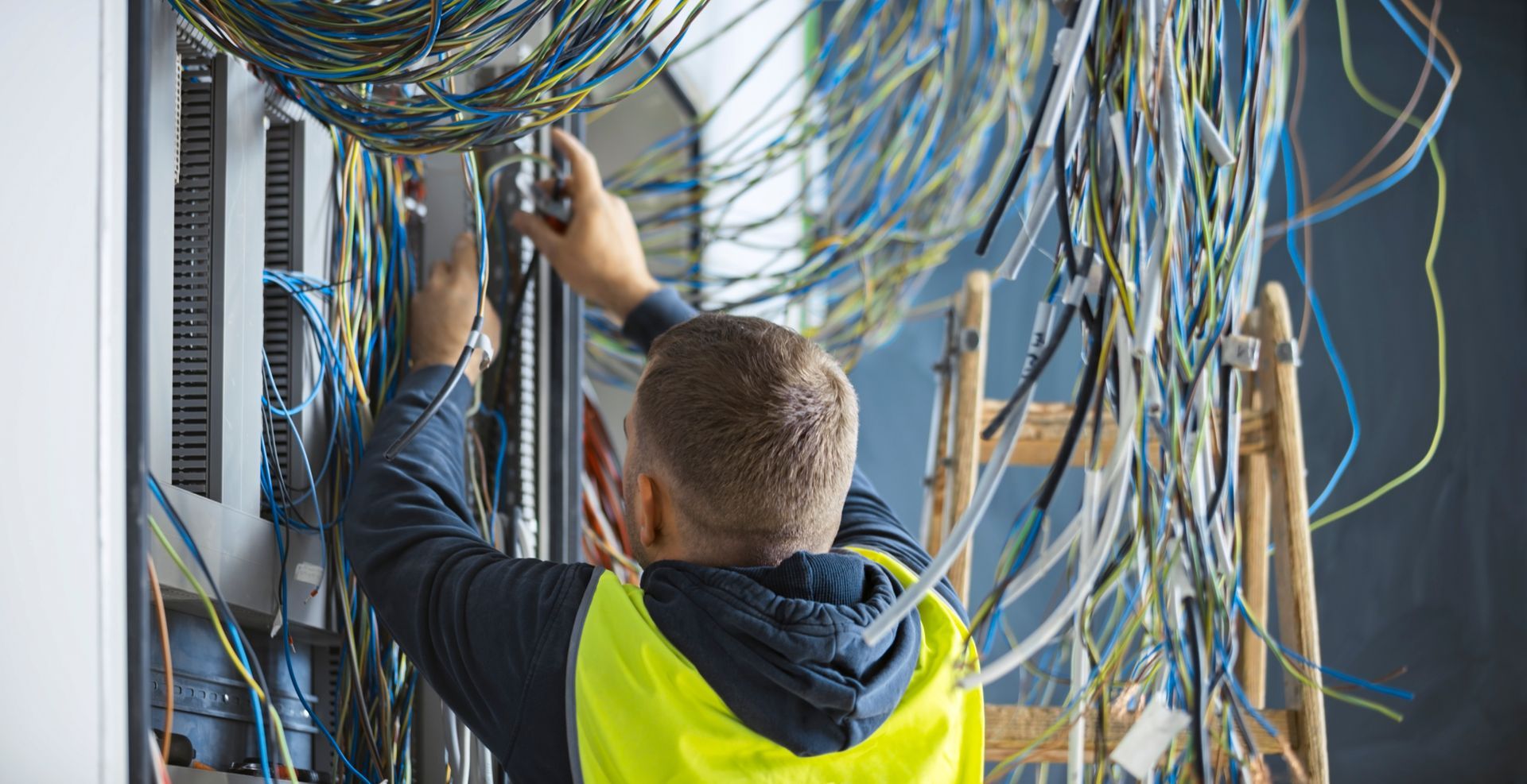 A man is working on a server in a server room.
