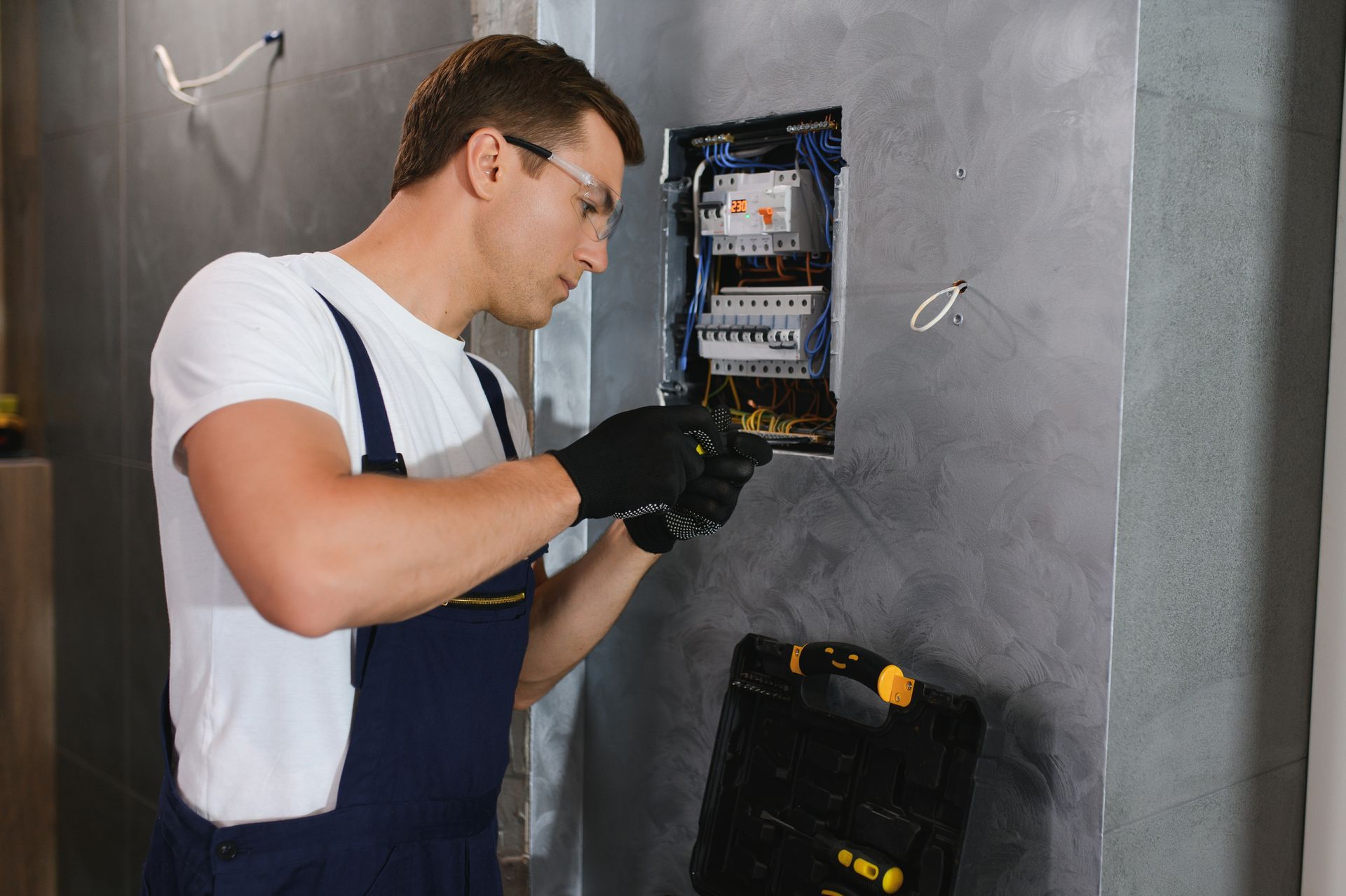 Electrician working on an electrical panel inside a home.