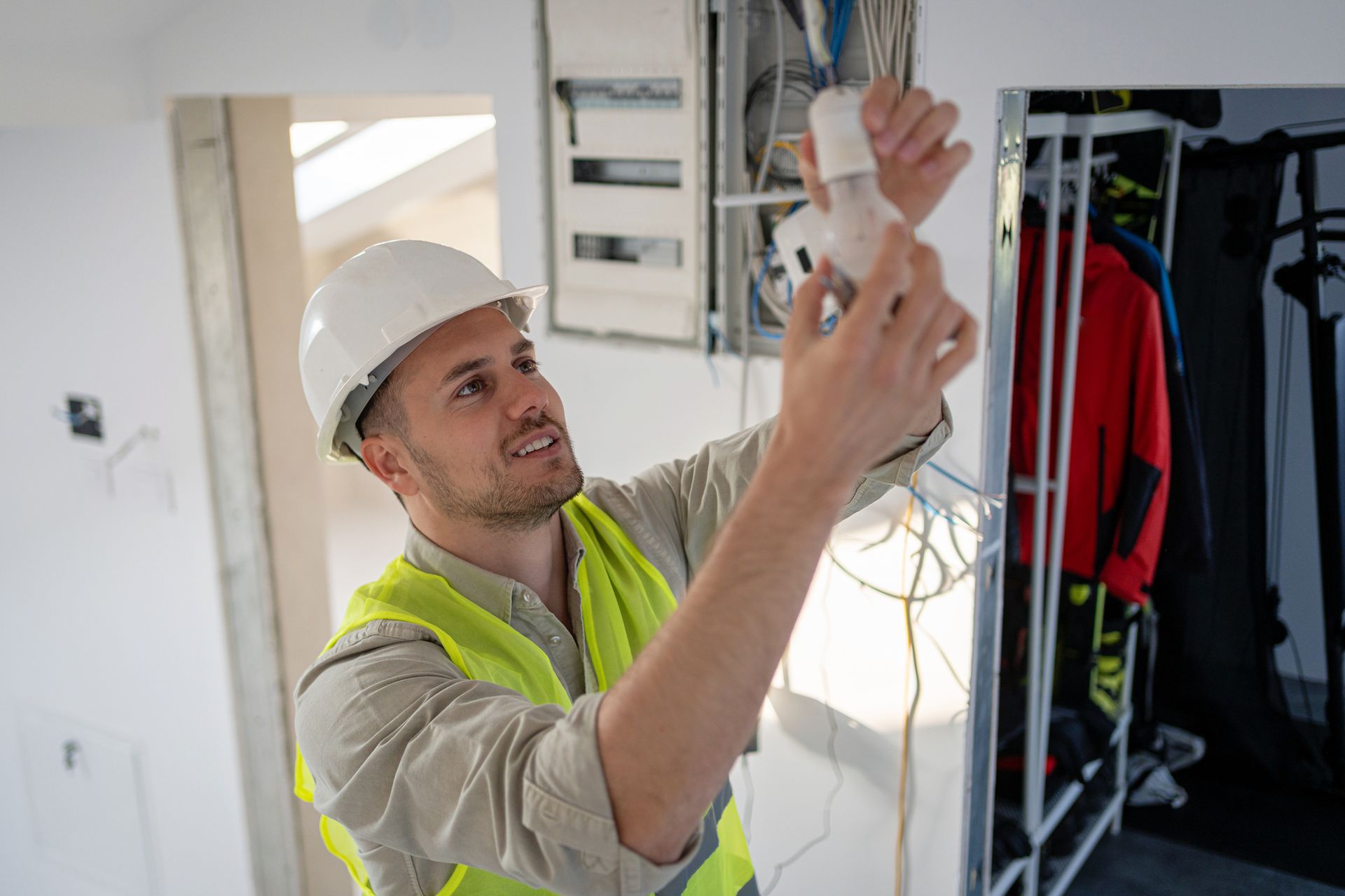 A man is changing a light bulb in a room.