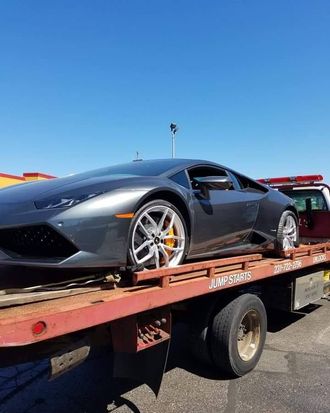 A lamborghini huracan is being towed by a tow truck.