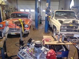 Two cars are being worked on in a garage