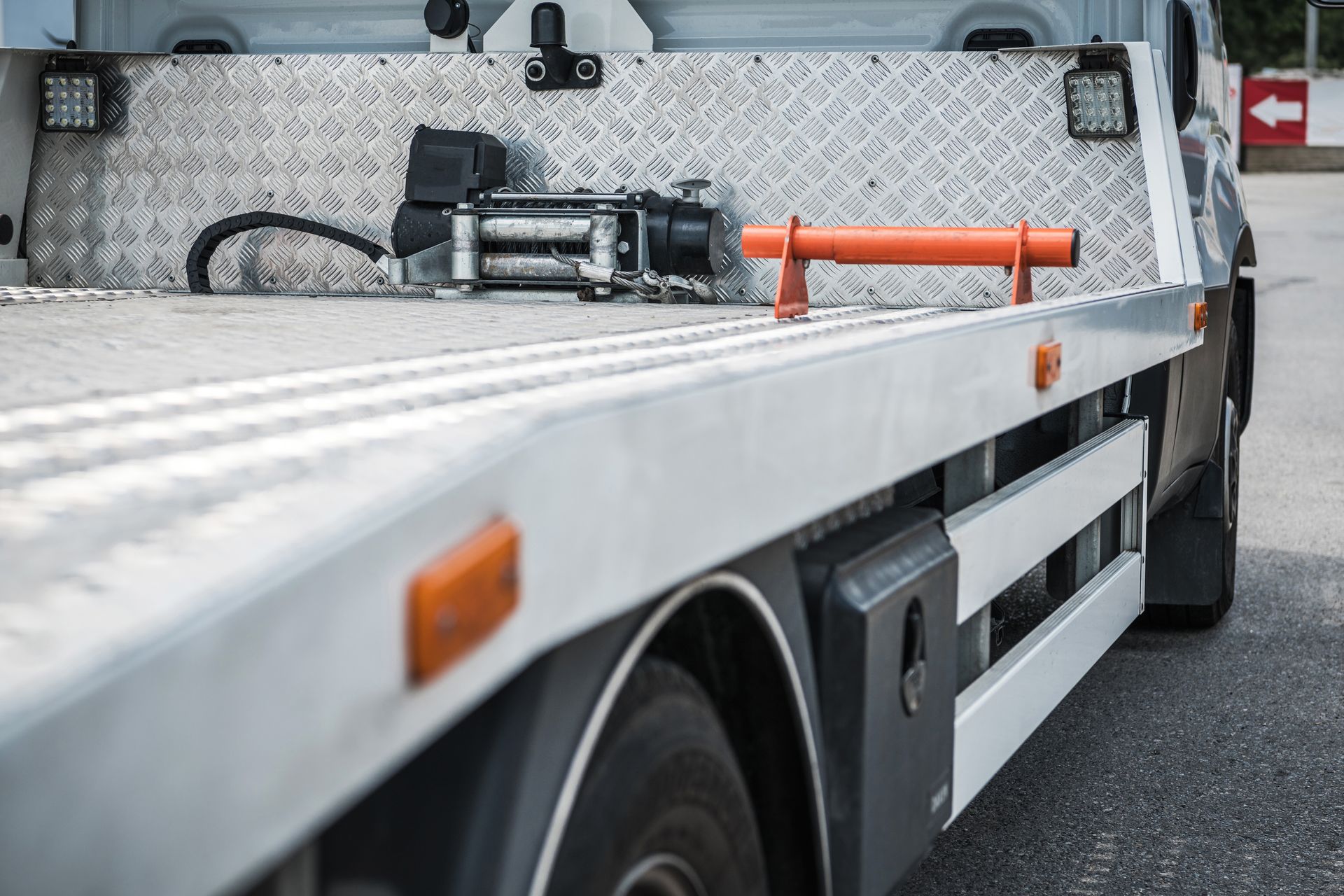 A white car is being towed by a campbell 's towing truck