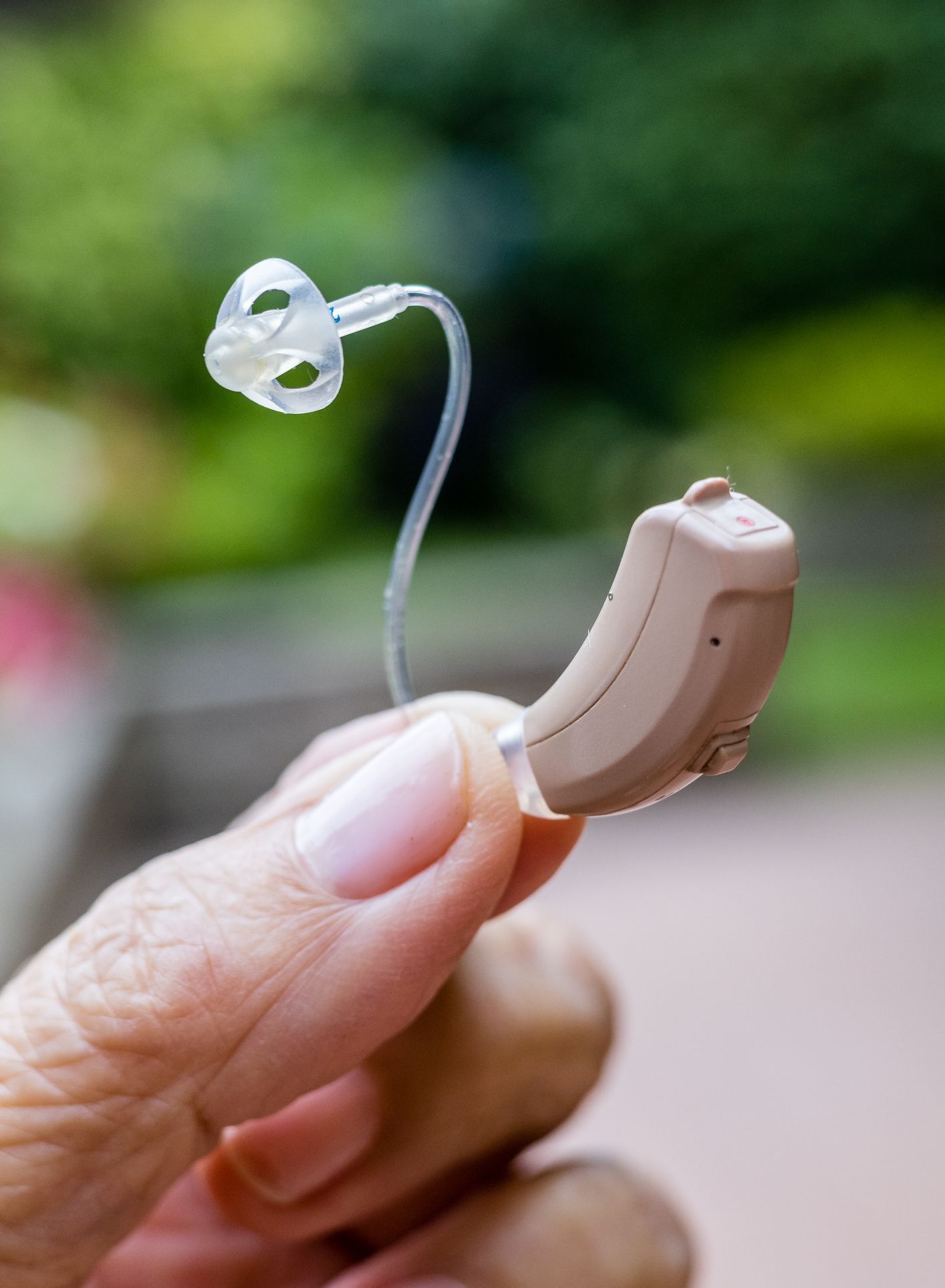 A woman in a yellow sweater is sitting on a couch and smiling.