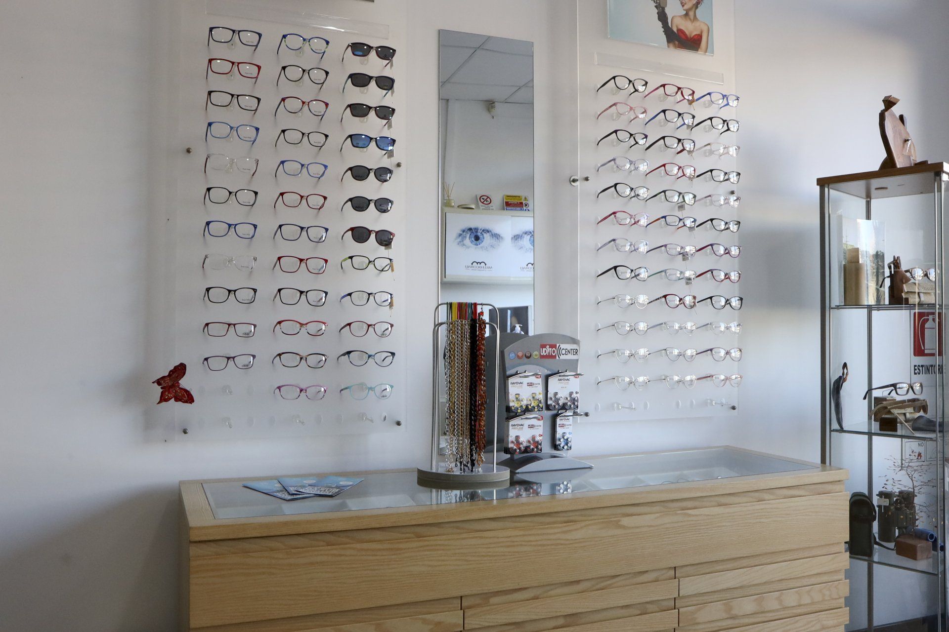 Montature per occhiali esposte su una parete in uno studio di optometria.