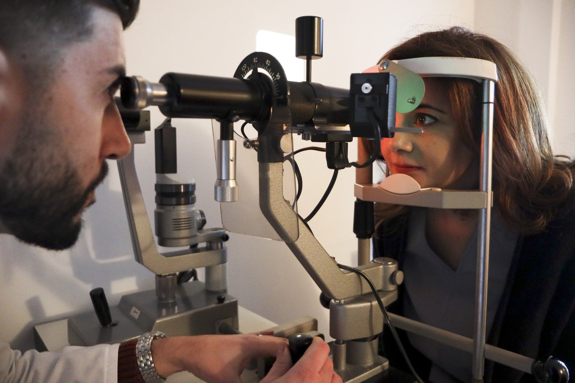 Un optometrista esamina gli occhi di una donna con una lampada a fessura in una sala visite.