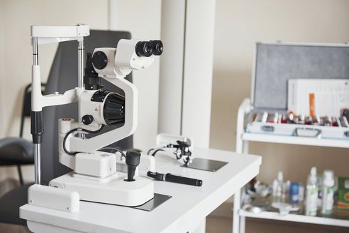 Attrezzatura per l'esame della vista nello studio di un oculista. Strumenti bianchi e argentati su un tavolo.