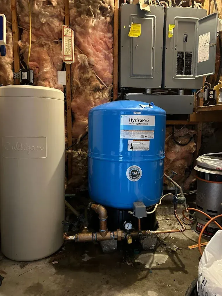 Water tanks and electrical panel in a basement setting.