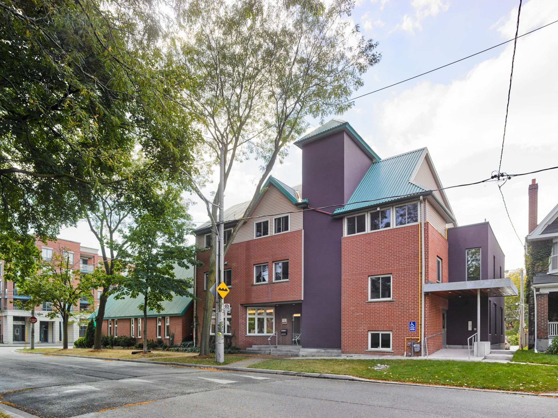 A brick building with a purple roof and a green roof