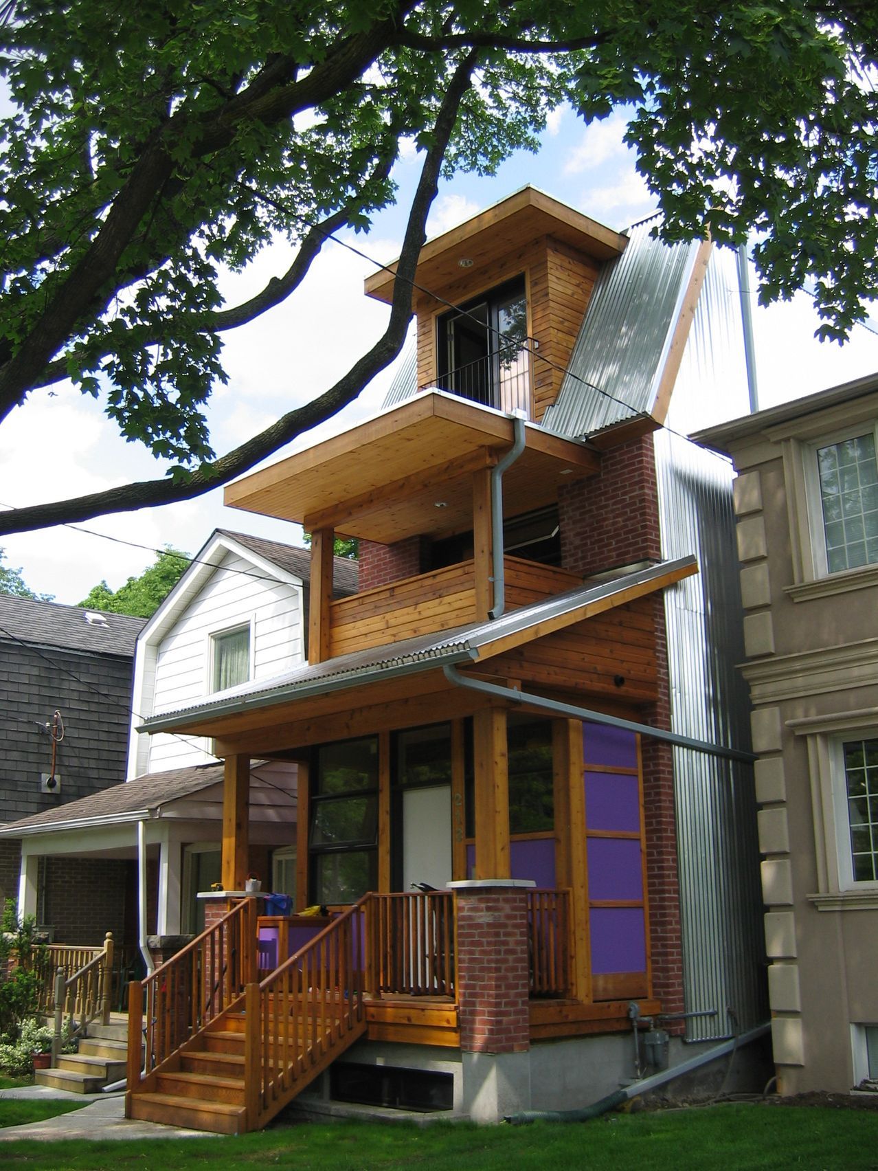 A brick house with a wooden deck and stairs