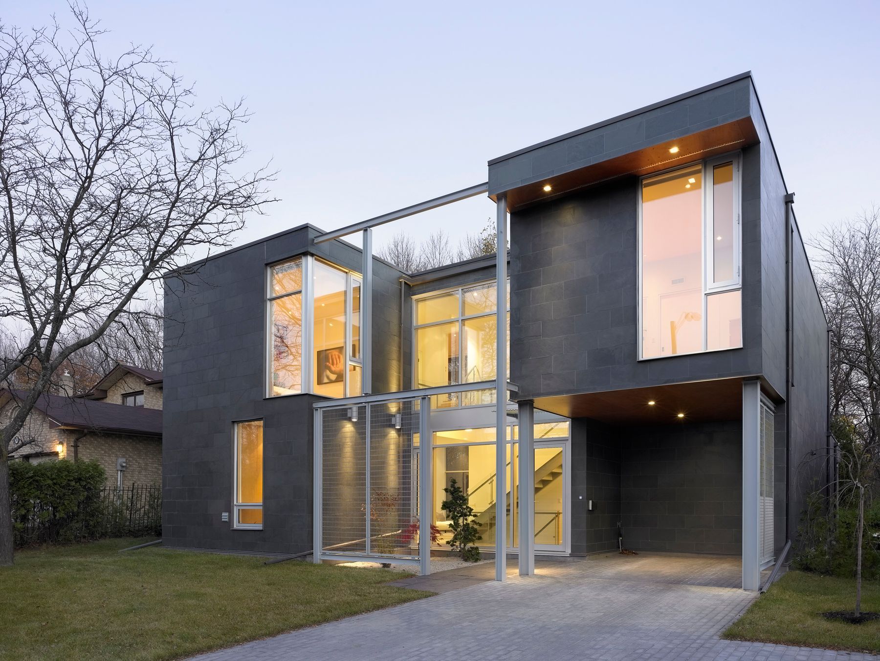 A modern house with a lot of windows and a driveway