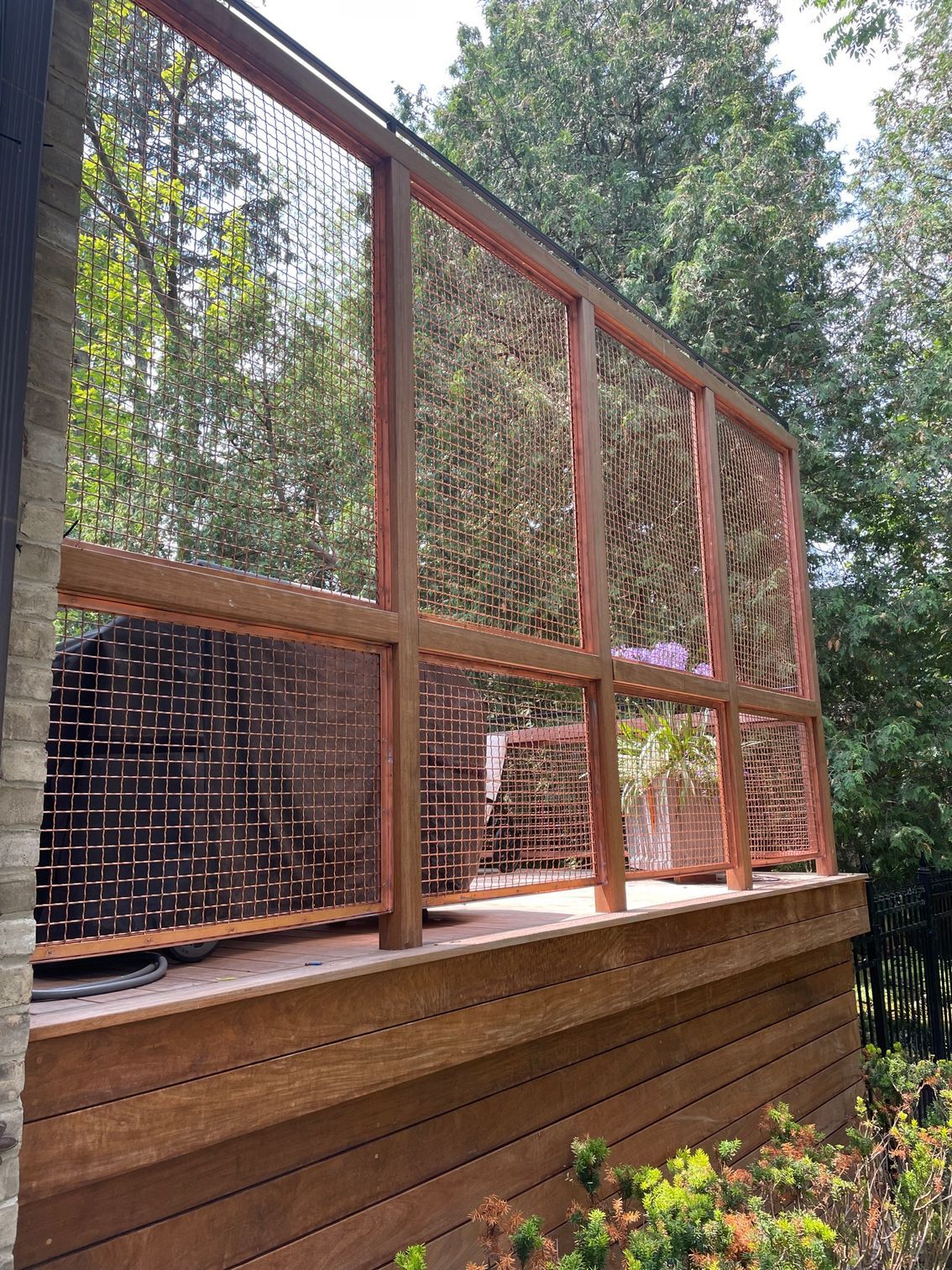 A wooden deck with a fence around it and trees in the background.