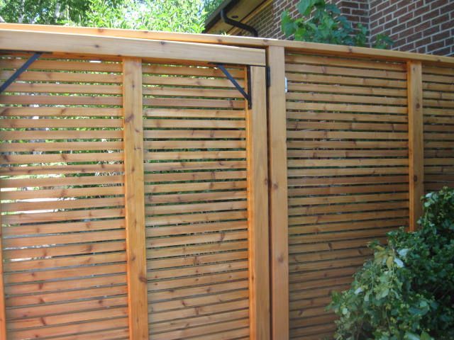 A wooden fence with a brick building in the background