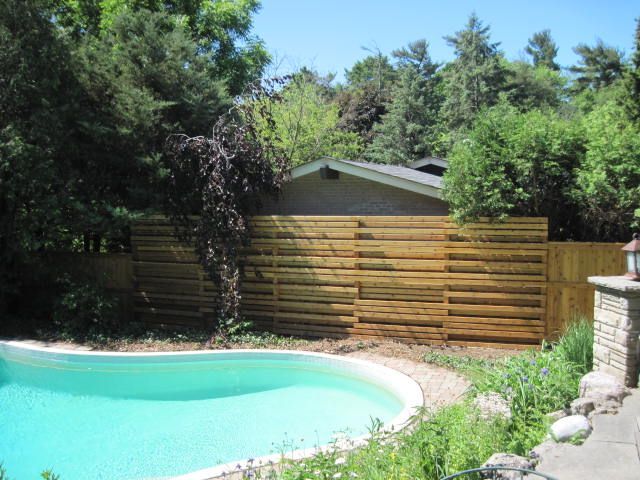 A swimming pool with a wooden fence surrounding it