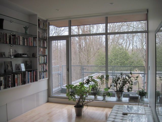 A living room with a lot of windows and bookshelves
