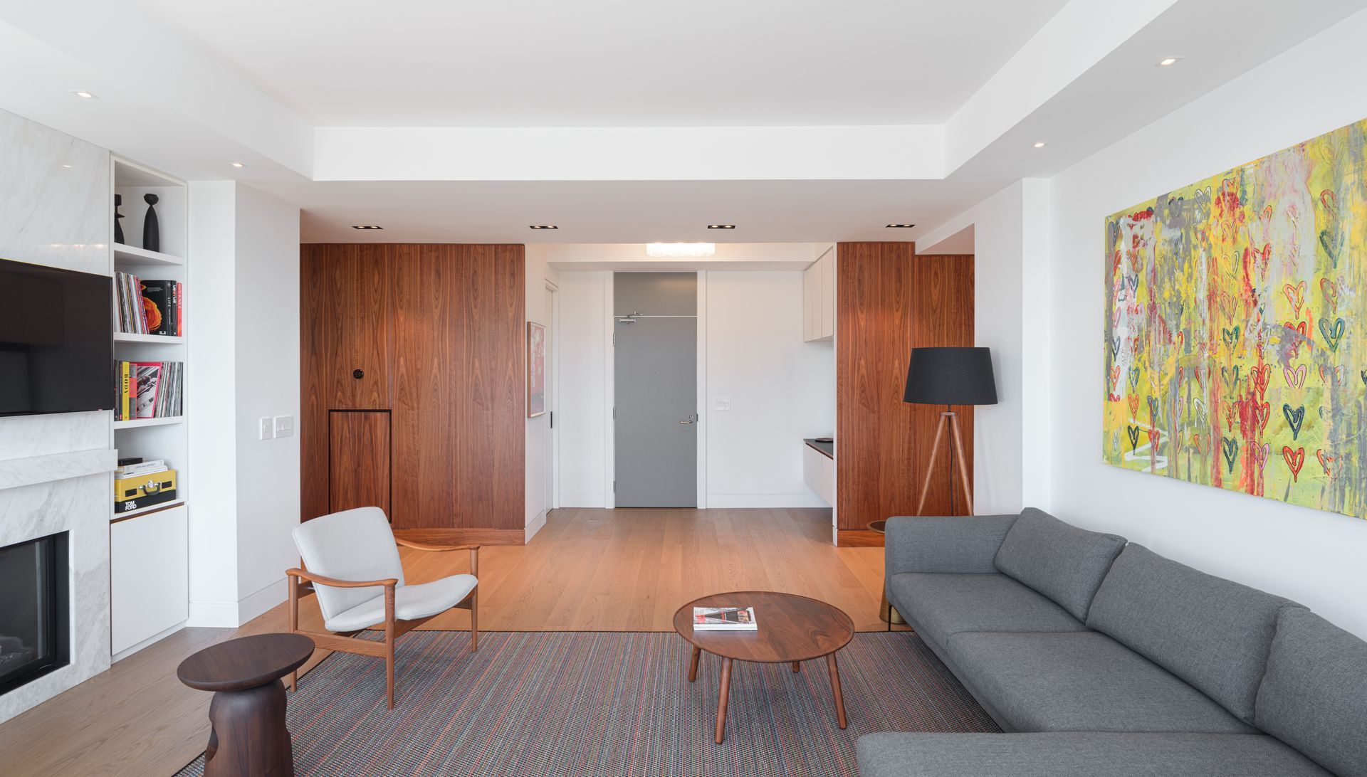 A living room with a couch , chair , table and fireplace.