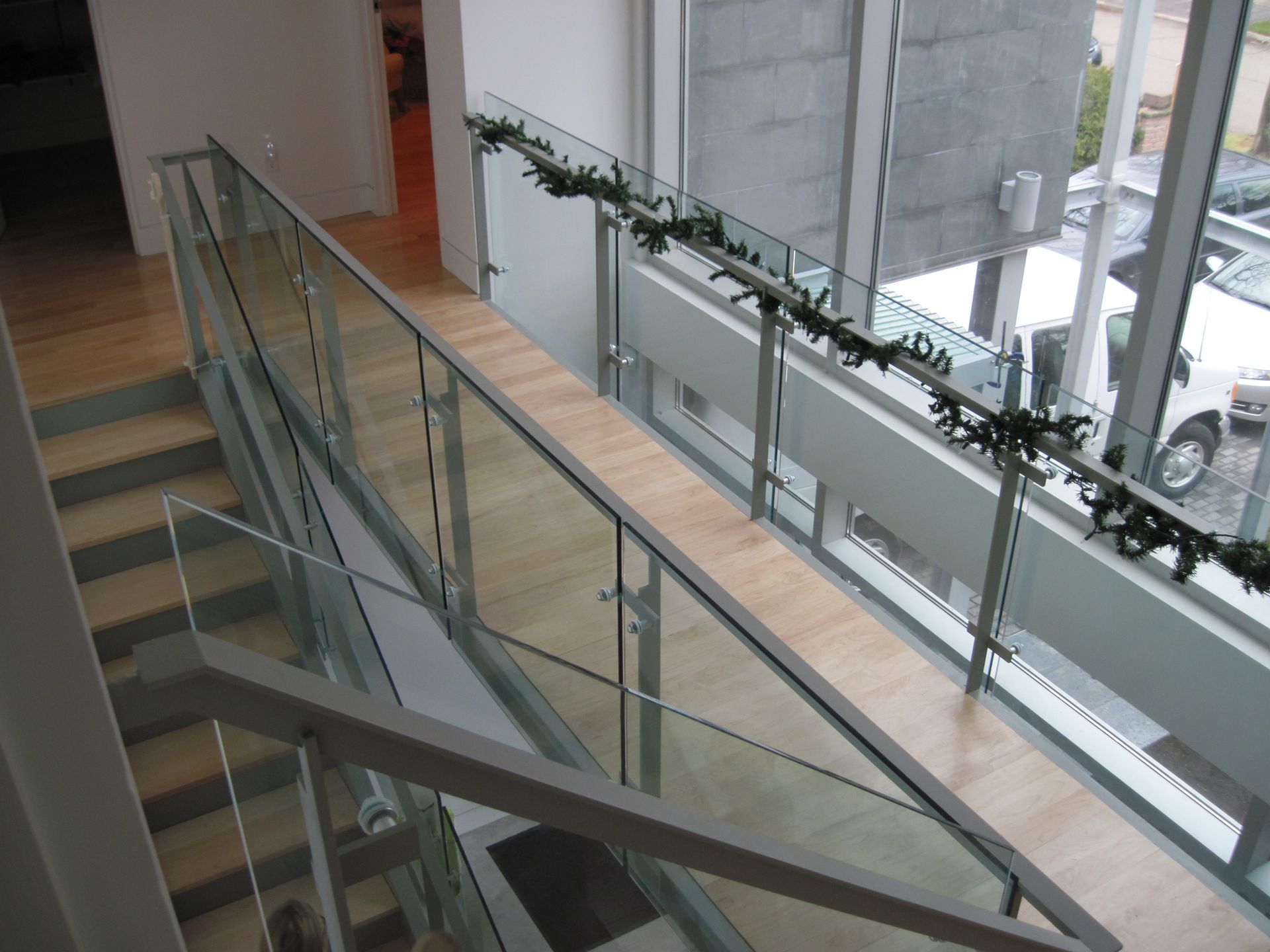 A staircase with a glass railing and a window