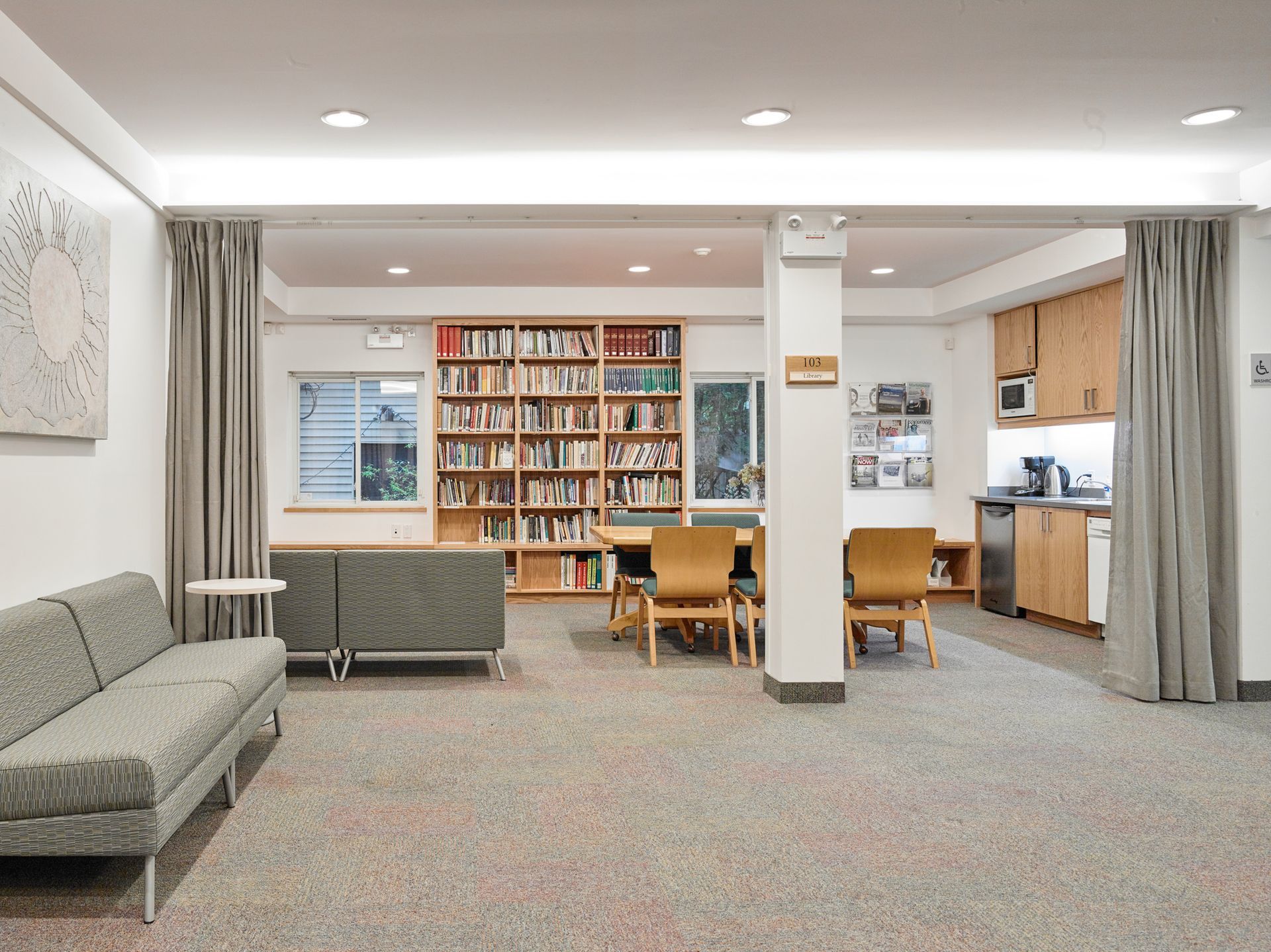 A living room with a couch , chairs and a bookshelf.