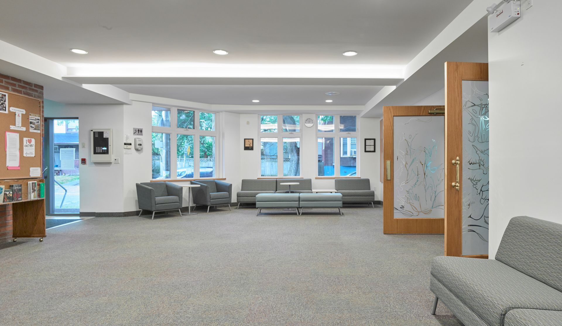 A large waiting room with a couch and chairs in it.