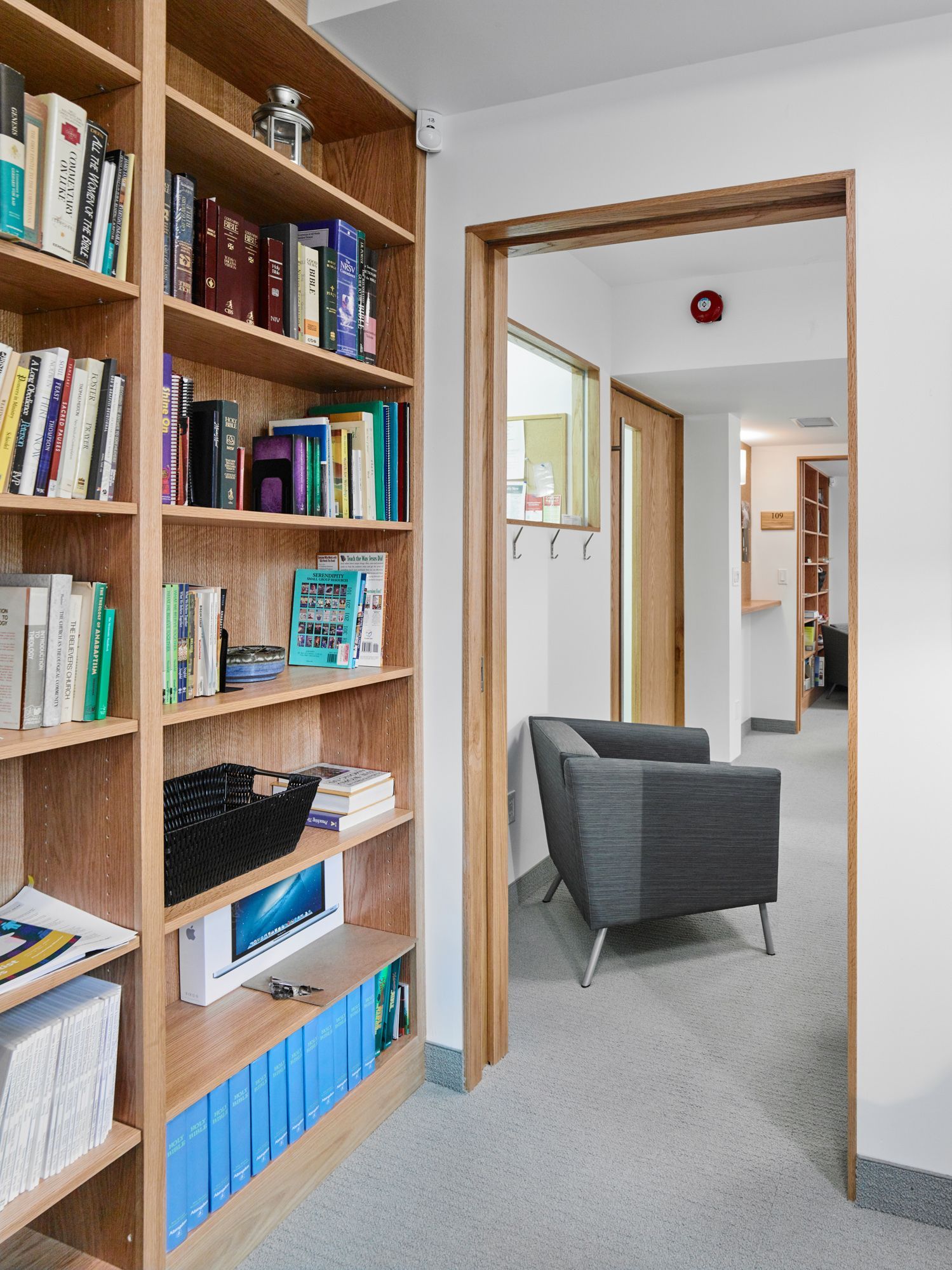 A hallway with a chair and shelves full of books
