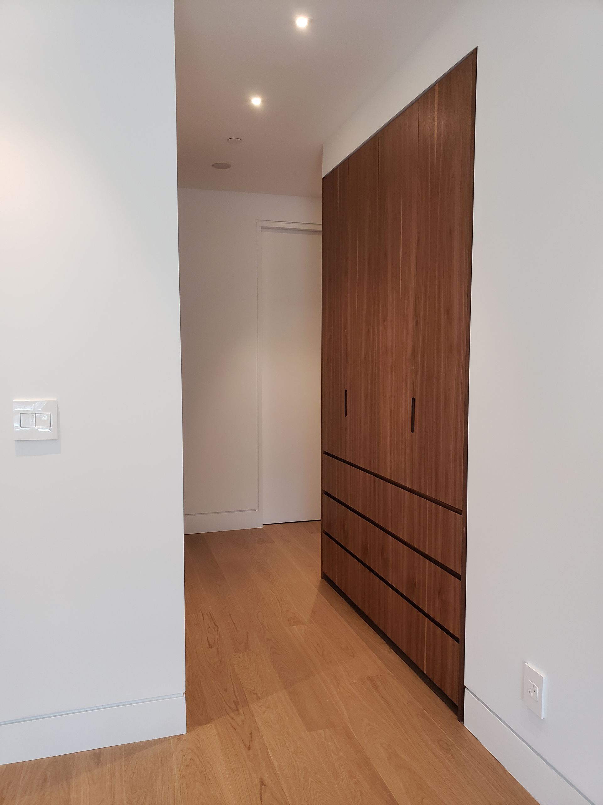 A hallway with wooden floors and white walls