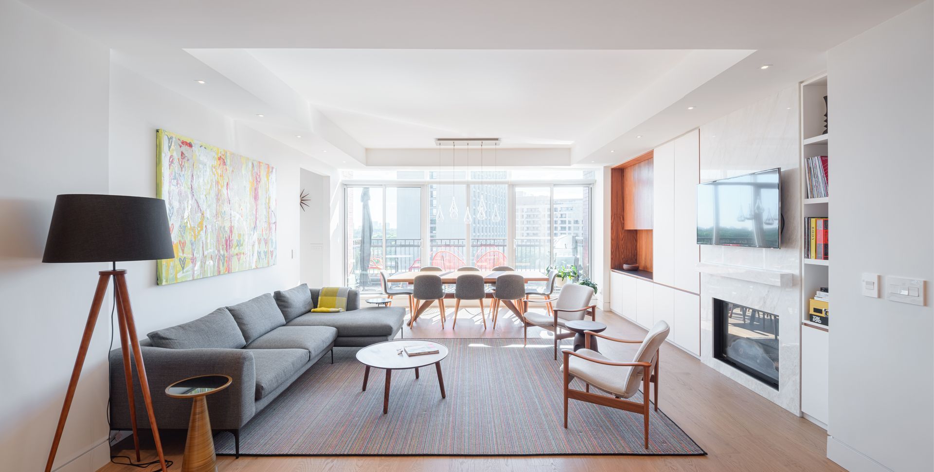 A living room with a couch , chairs , table and fireplace.