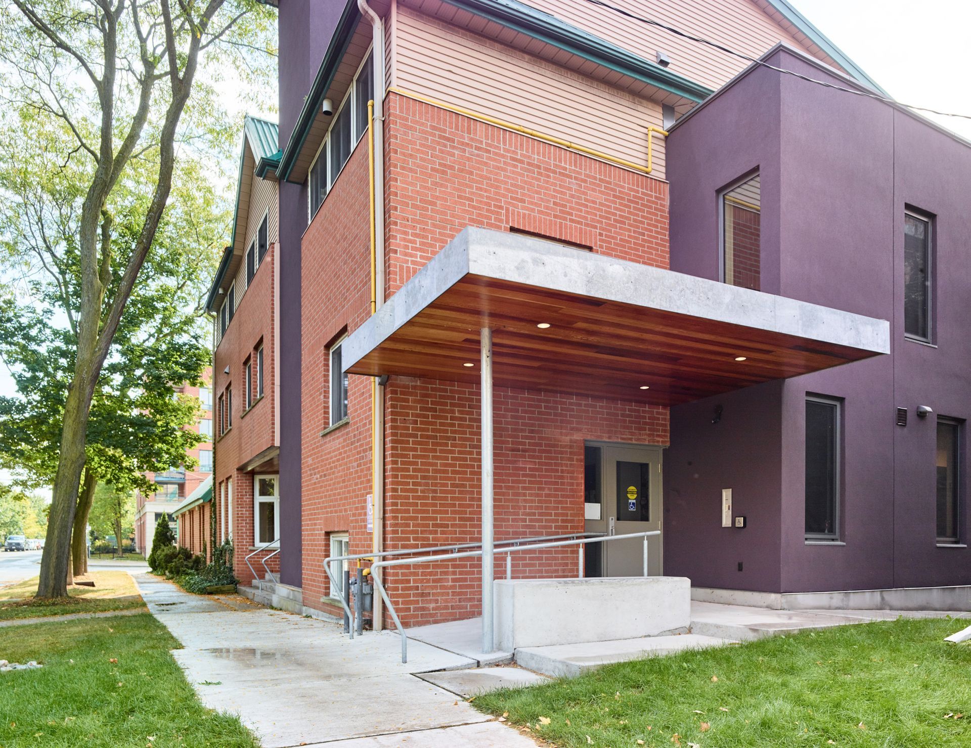 A brick building with a purple roof and a ramp