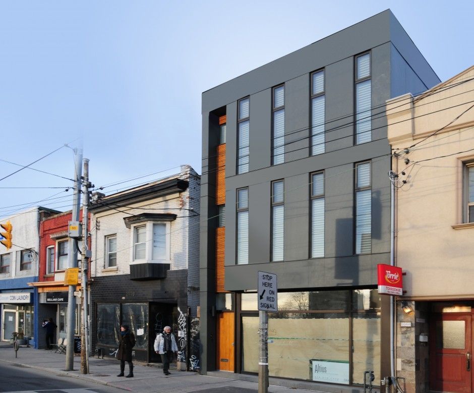 A large building with a lot of windows is surrounded by smaller buildings