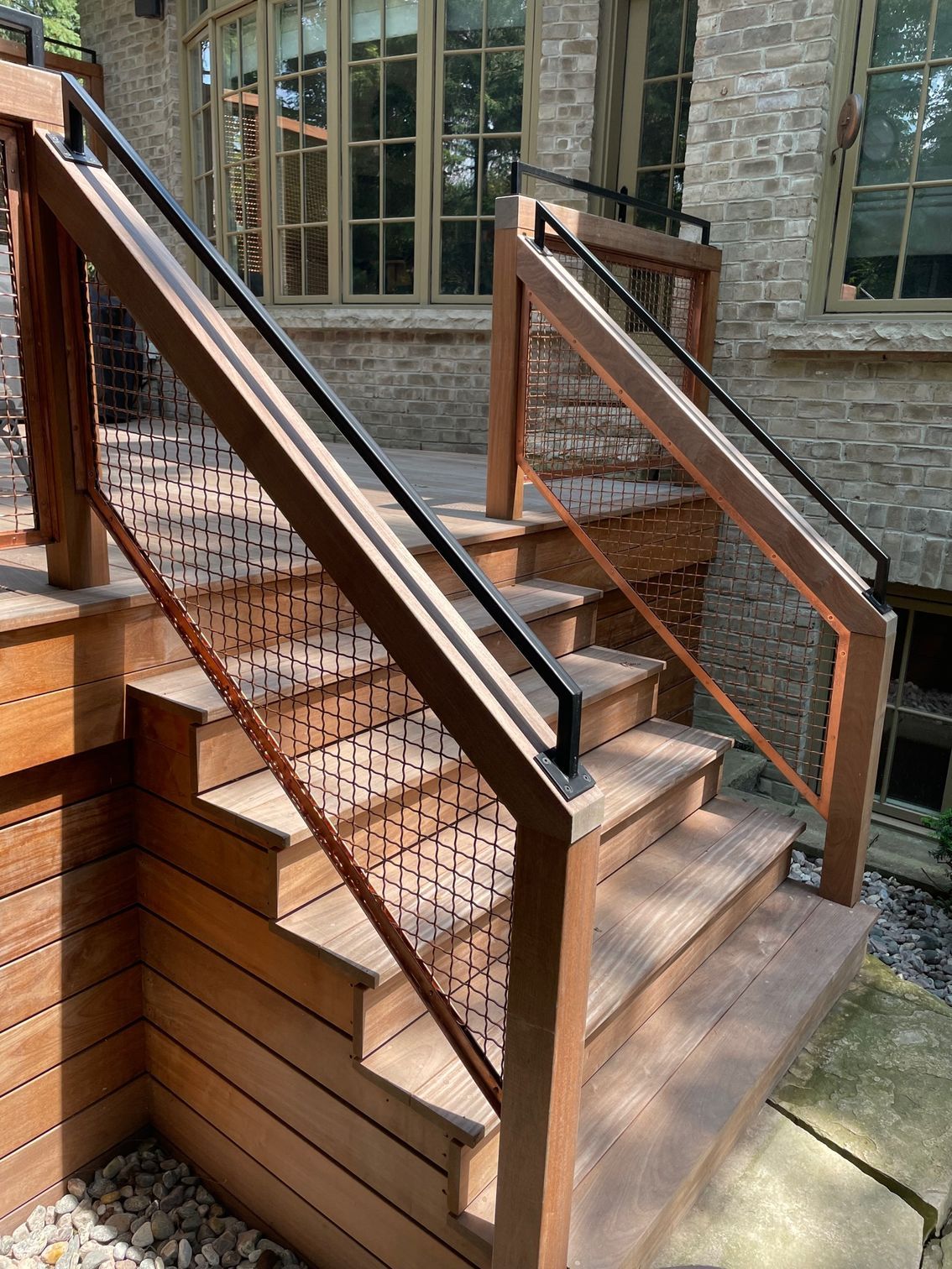 A wooden deck with stairs and a metal railing.