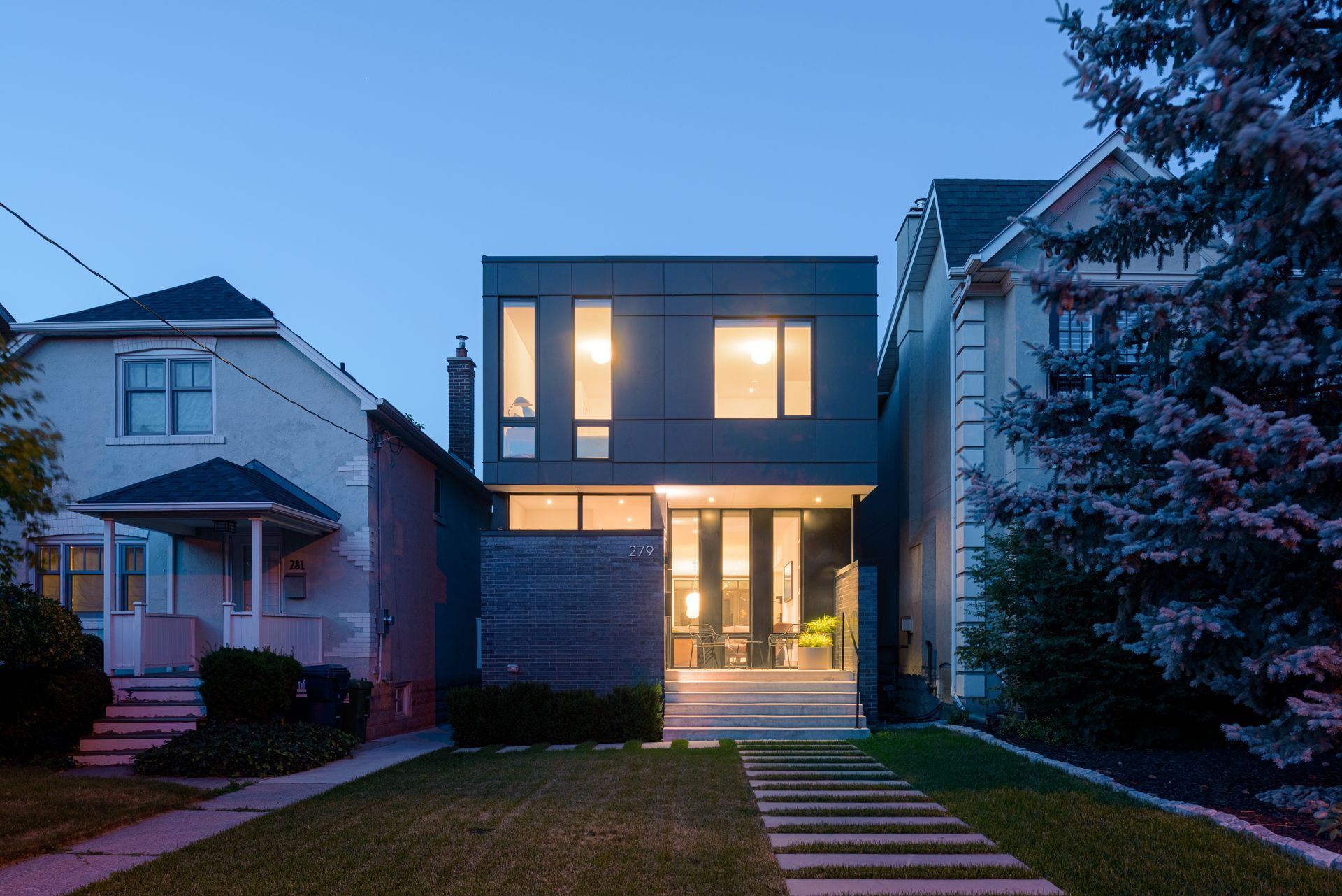 A house with a lot of windows is lit up at night