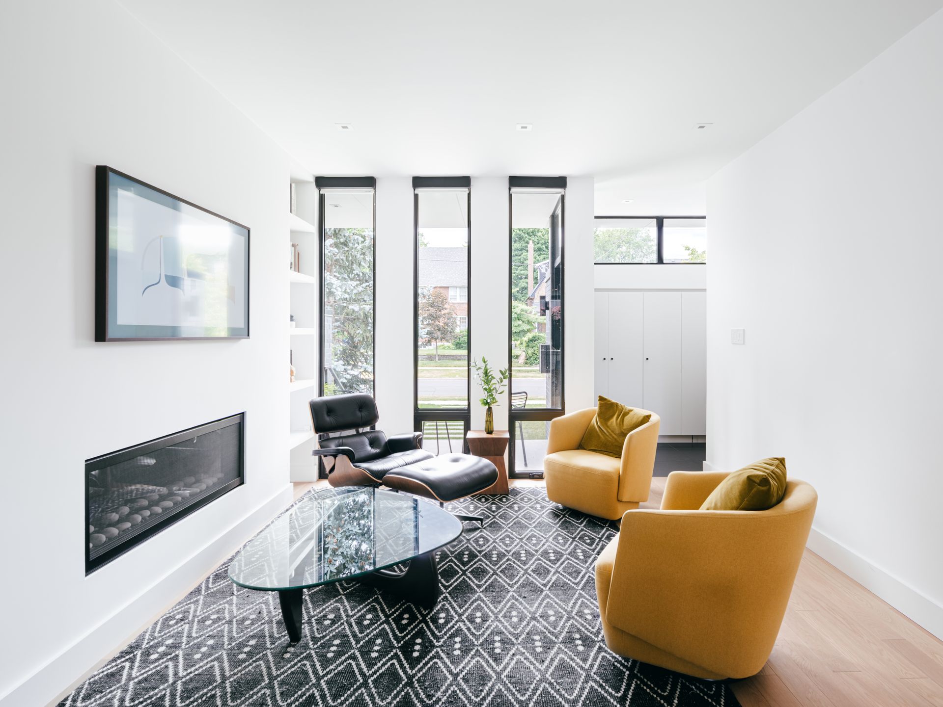 A living room with two yellow chairs , a coffee table , and a fireplace.