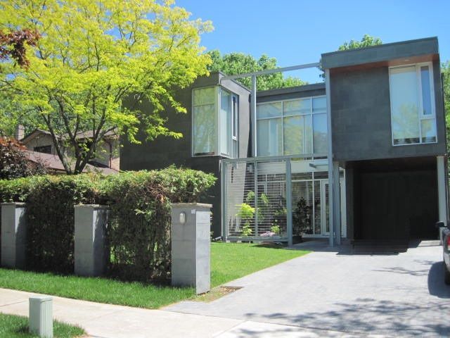 A car is parked in front of a modern house
